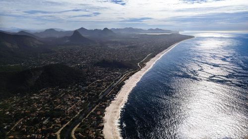 High angle view of sea and mountains against sky