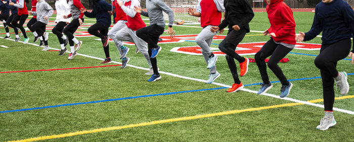 Low section of people running at soccer field