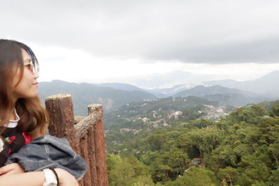 Woman looking at mountains against sky