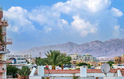 Buildings in town against cloudy sky