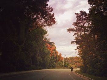 View of country road against cloudy sky