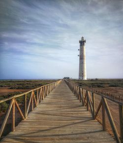 Footpath leading towards lighthouse against sky in fuerteventura