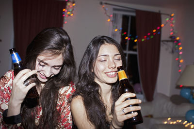 Young women drinking beer from bottles
