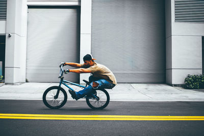 Man with bicycle on road in city