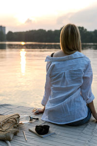 Young woman is resting in the evening by the lake.