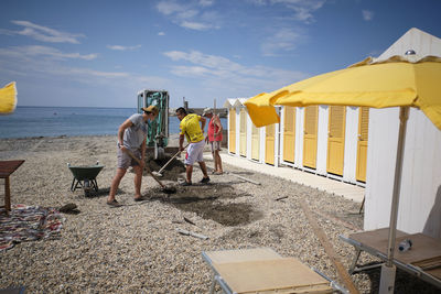 People at beach against sky