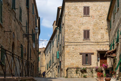 Street amidst buildings in town against sky