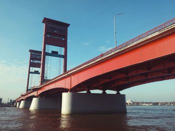 Low angle view of bridge over river against sky