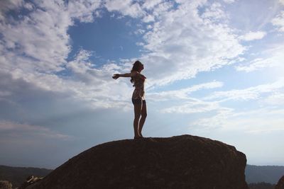 Low angle view of man standing on rock