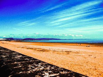 Scenic view of beach against blue sky