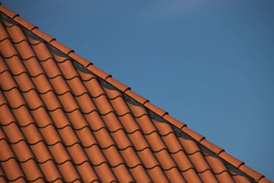 Low angle view of roof tiles against clear sky