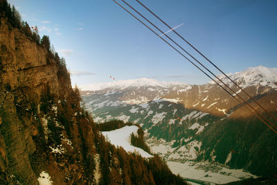 Overhead cable car over mountains against sky