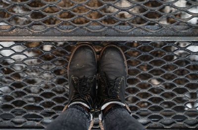 Photo of dark gray boots from above. dirty shoes on a metal surface