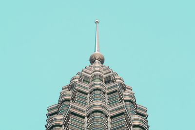 High section of petronas towers against blue sky