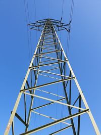 Low angle view of electricity pylon against clear sky