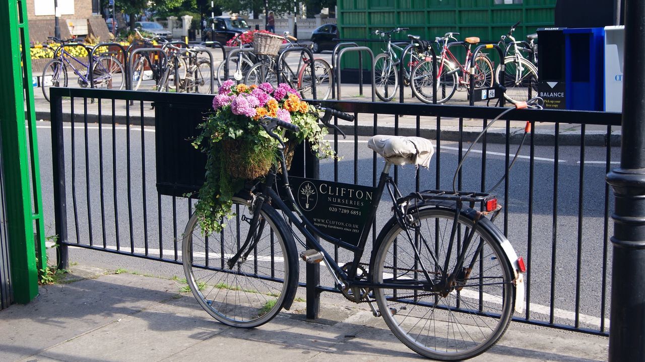 BICYCLE PARKED ON STREET AGAINST WALL