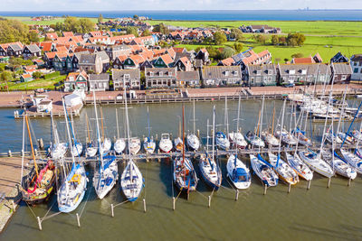 High angle view of boats moored on sea against buildings in city