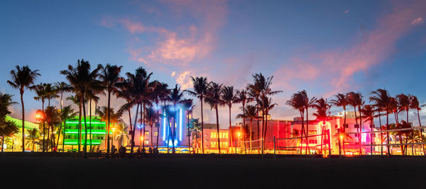 Illuminated buildings against sky at night