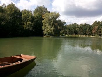 Scenic view of calm lake against cloudy sky