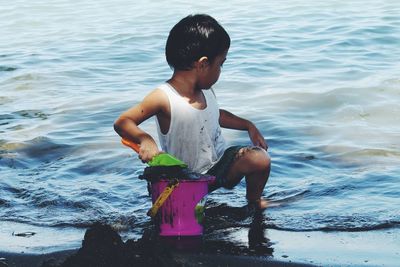 Full length of boy playing in sea