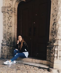 Portrait of smiling young woman sitting outdoors