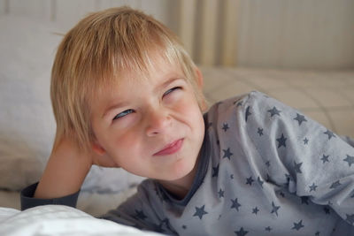 Close-up of cute baby boy lying on bed at home