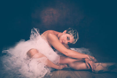 Portrait of mature woman sitting in darkroom