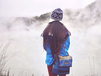 Rear view of woman standing against sky