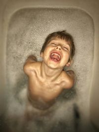 Close-up of happy boy in bathtub