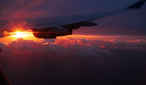 Airplane flying in sky during sunset