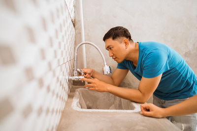 Side view of young man working at home