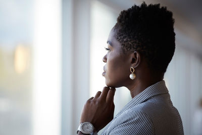 Side view of female entrepreneur looking away while standing at workplace