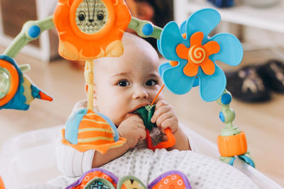 Cute chubby baby playing with colorful toys. sweet infant at home