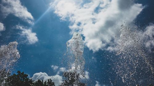 Low angle view of water splashing against sky