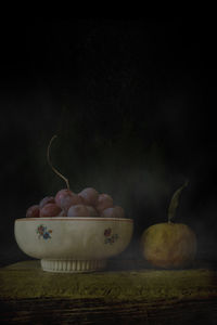 Close-up of fruits on table against black background