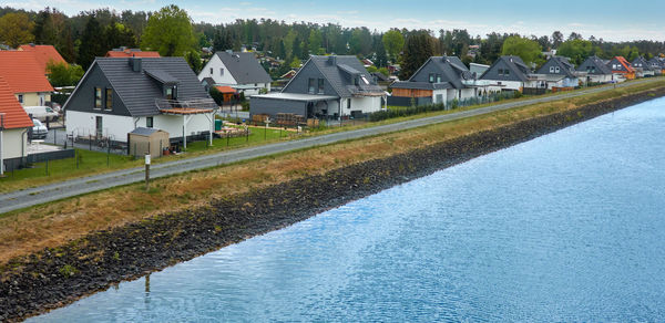 Monotonous settlement of similar detached houses on the edge of a canal in germany