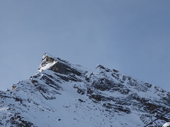 Low angle view of snowcapped mountain against sky