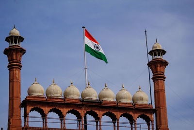 Low angle view of flags on building against sky