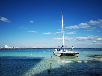 Sailboat sailing on sea against blue sky