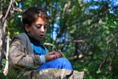 Close-up of a boy sitting outdoors