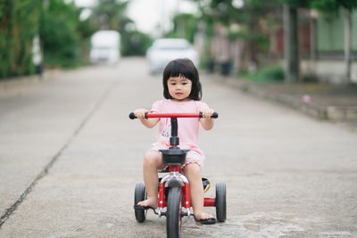 Portrait of cute boy riding toy car