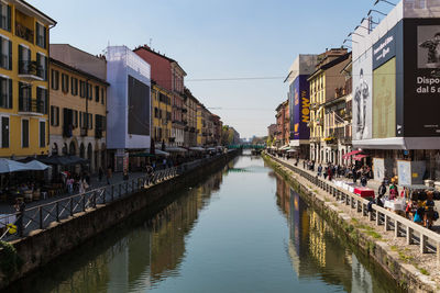 Canal amidst buildings in city against sky