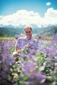 Woman standing on purple flowering plants