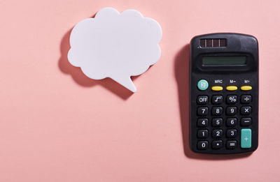 Directly above shot of calculator on pink background