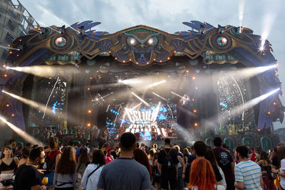 People in amusement park against sky