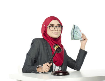 Portrait of young woman wearing mask against white background