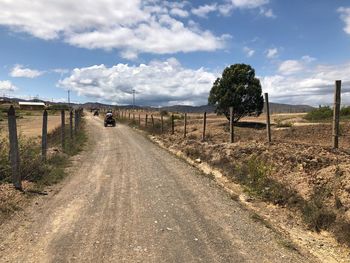 Empty road on field against sky