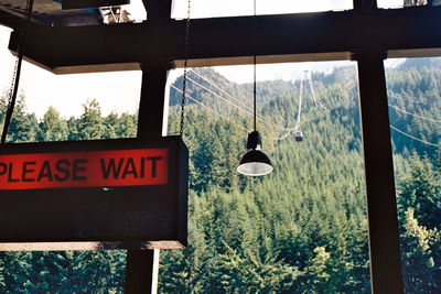 Low angle view of lighting equipment seen through window