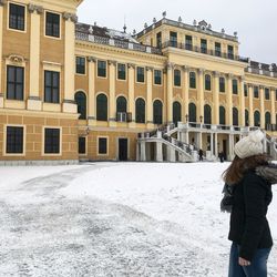 Woman standing on snow covered city in winter