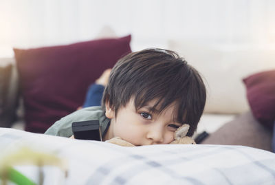 Portrait of boy lying on bed at home